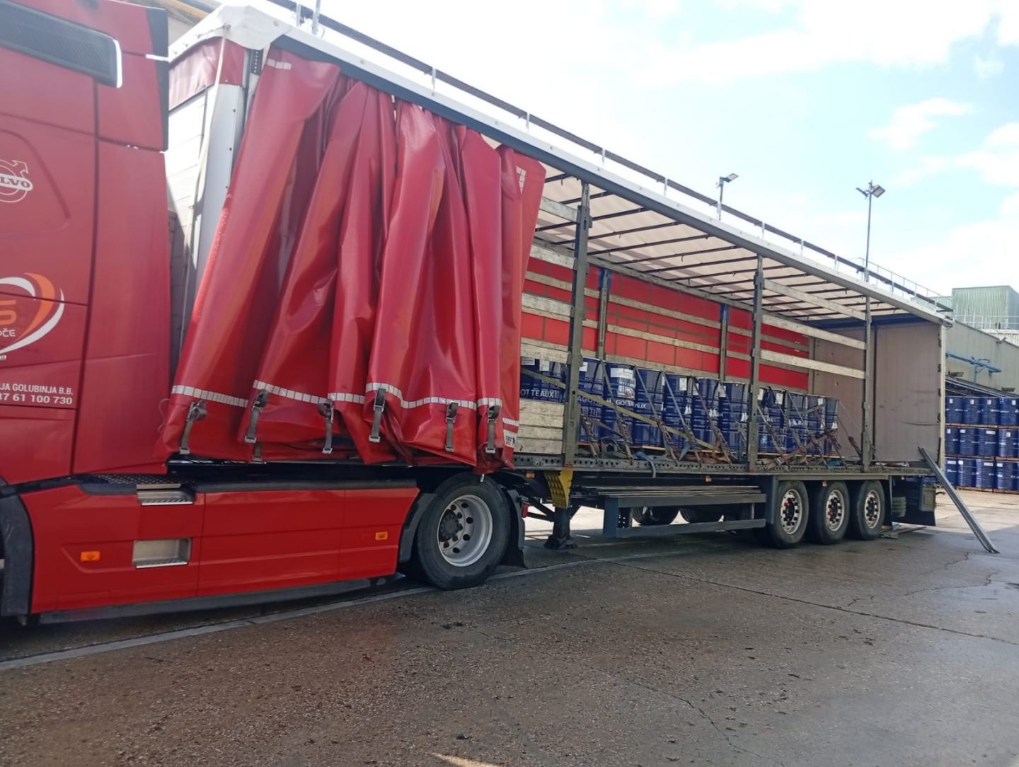 Curtainsider truck loaded with steel drums