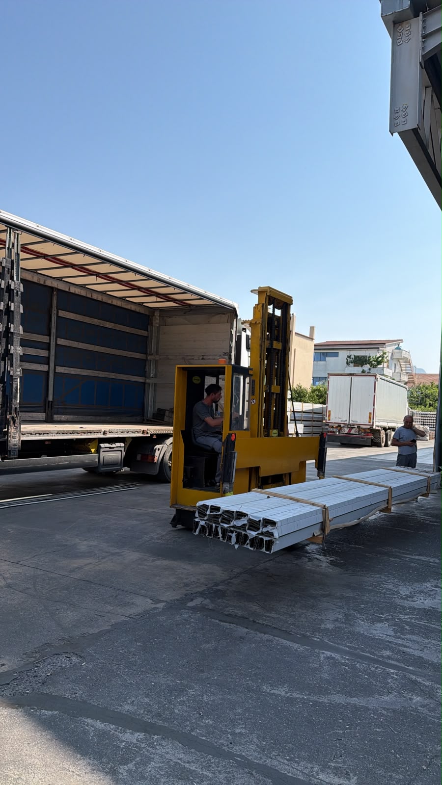 Forklift loading steel profiles onto truck